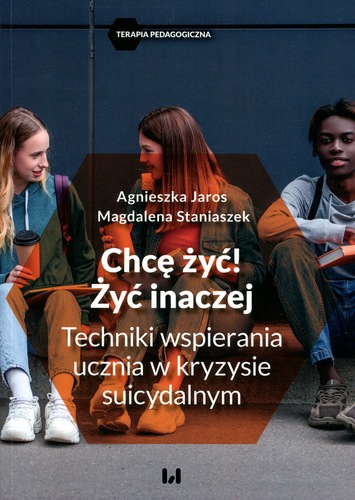Okładka książki z serii „Terapia Pedagogiczna” przedstawia trójkę młodych ludzi siedzących razem w swobodnej atmosferze, rozmawiających i trzymających napoje. Tytuł brzmi: „Chcę żyć! Żyć inaczej. Techniki wspierania ucznia w kryzysie suicydalnym”, a autorkami są Agnieszka Jaros i Magdalena Staniaszek. Ciemne tło kontrastuje z jasnymi elementami, podkreślając powagę tematu. Książka ma na celu wsparcie nauczycieli i pedagogów w pracy z uczniami przeżywającymi kryzys emocjonalny.