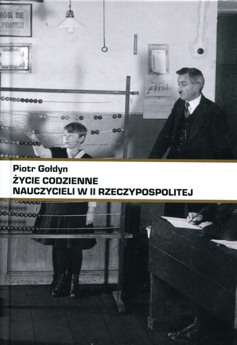 Na obrazie widoczna jest okładka książki Piotra Gołdyna pt. „Życie codzienne nauczycieli w II Rzeczypospolitej”. Centralnym elementem jest czarno-biała fotografia archiwalna przedstawiająca scenę z dawnej sali lekcyjnej. Po prawej stronie stoi nauczyciel ubrany w formalny, ciemny strój – marynarkę i krawat – obok biurka lub katedry. Jego postawa jest poważna i oficjalna, co oddaje autorytet nauczyciela w okresie międzywojennym. Po lewej stronie widoczny jest uczeń, stojący przy tablicy lub specjalnym pulpicie dydaktycznym, najpewniej odpowiadający na pytanie lub biorący udział w lekcji. W tle widać elementy wyposażenia klasy: tablice, plansze dydaktyczne oraz urządzenia lub pomoce naukowe, co podkreśla realia szkolnictwa w II Rzeczypospolitej. Całość utrzymana jest w surowej, dokumentalnej stylistyce, charakterystycznej dla fotografii z początku XX wieku. Na dole okładki znajduje się pas z tytułem książki i nazwiskiem autora, który wyraźnie kontrastuje z fotografią i porządkuje kompozycję. Okładka jednoznacznie sugeruje historyczno-edukacyjny charakter publikacji, poświęconej codzienności pracy nauczycieli oraz realiom szkoły w okresie międzywojennym.